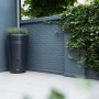 Schwarze Elho Regentonne Green-Basics 200L mit integriertem Blumentopf im Garten.