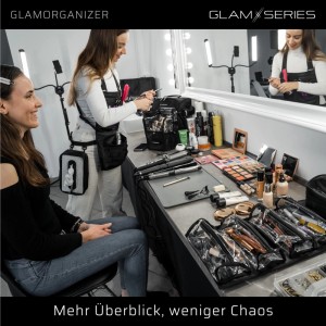 Glamorganizer Kosmetiktasche mit transparenten Inlays und Make-up-Produkten auf Theke, Artist schminkt Kundin im Studio.