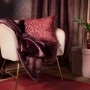 Hochflor-Teppich Blush Bordeaux (140x80 cm) auf Sessel mit Kissen und Decke im Boudoir-Stil.