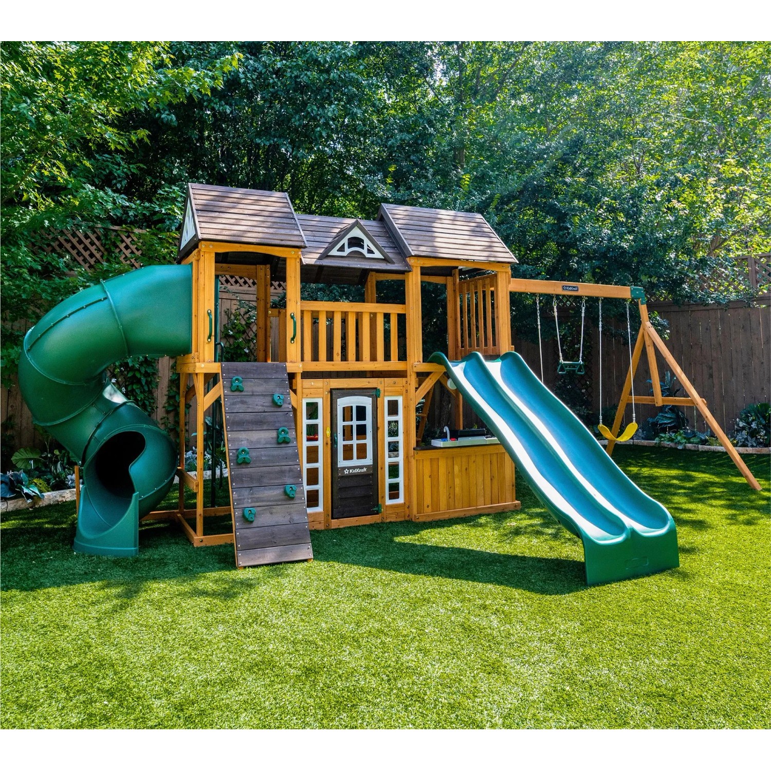 Zwerkules Spielturm Bolzo mit Rutschen, Schaukel und Kletterwand im Garten.