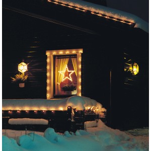 Beleuchteter Stern als LED-Silhouette im Fenster eines Hauses, weihnachtliche Dekoration.