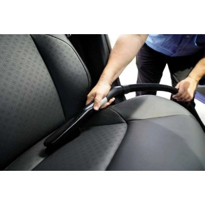 Einhell Polsterbürste hart im Einsatz zur Reinigung eines dunklen Autopolsters.