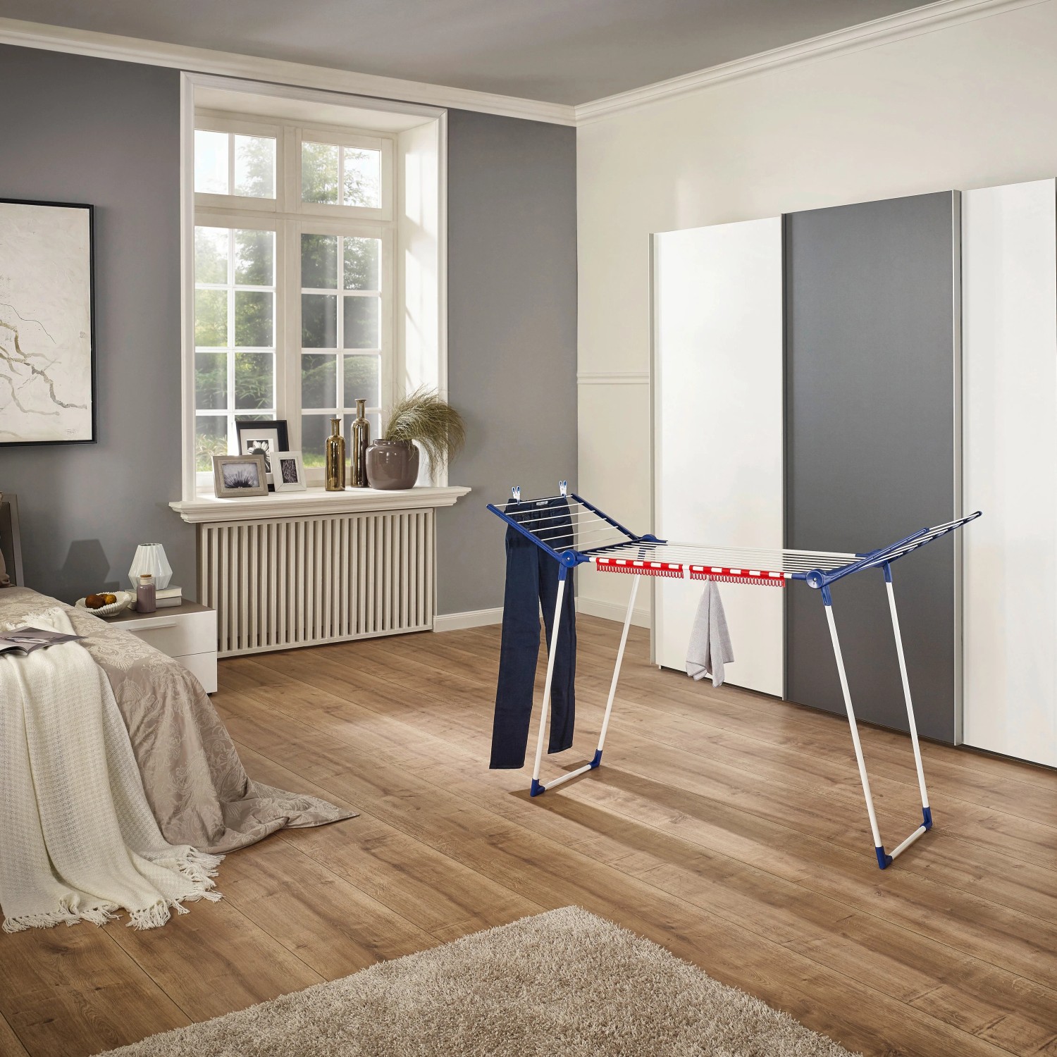 Leifheit Wäscheständer Pegasus 150 Solid Slim mit Wäsche in einem hellen Raum.