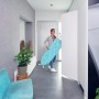 Leifheit Bügeltisch AirBoard Compact M Plus, blau gemustert, mit Frau im Flur.