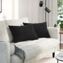 Zwei schwarze Sofakissen (60x40 cm) aus Cordstoff auf einem weißen Sofa.