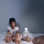 Mädchen im Kinderzimmer mit Osram LED-Nachtlicht Lunetta Hall an der Wand.