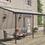 Graues Palram Terrassendach Sierra 447x230 cm mit Sitzgruppe auf Holzterrasse.