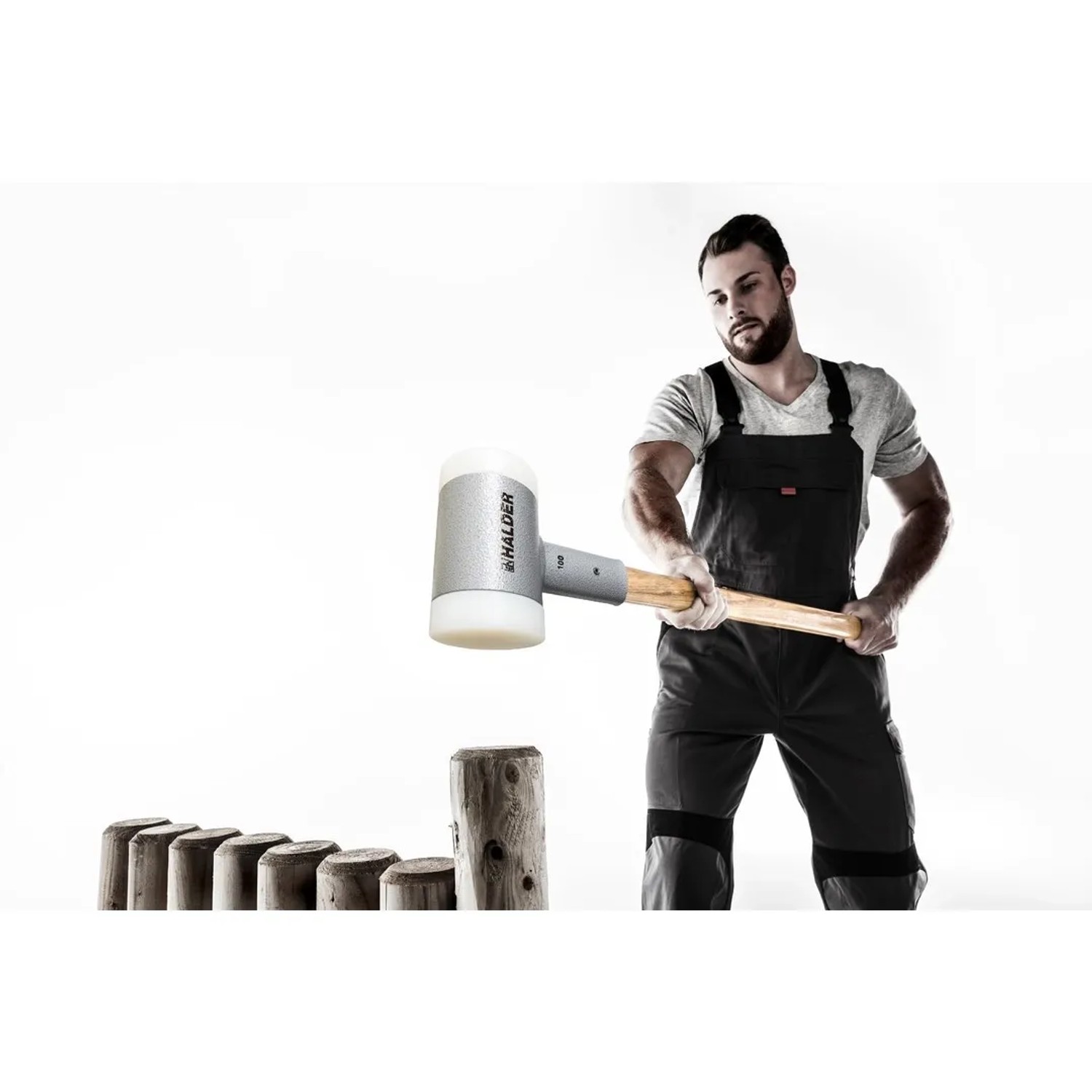 Mann beim Einschlagen eines Holzpfahls mit Halder Schlegel Ø 100 mm. Rückschlagfreier Hammer mit Hickory-Stiel.