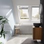 Helles Badezimmer mit Velux Integra Solarfenster GGU FK06 007030 in Weiß.