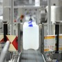 Flambiol Bioethanol 96,6% in Kanistern auf einem Förderband.