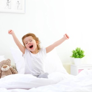 Kind wacht auf neben weiß-rosa Nachttisch. Relaxdays Nachttisch im Kinderzimmer.