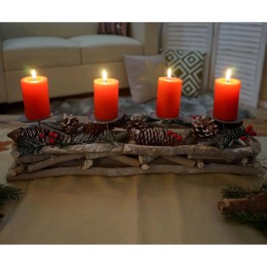 Länglicher Adventskranz aus Holz mit Tannenzweigen, Zapfen, roten Beeren und vier brennenden roten Kerzen.