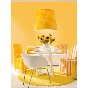 Szene in Honiggelb: Wandfarbe, Lampe, Teppich und Möbel im Farbton Honey von Schöner Wohnen.