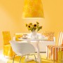 Szene in Honiggelb: Wandfarbe, Lampe, Teppich und Möbel im Farbton Honey von Schöner Wohnen.