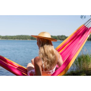 Frau entspannt in pink-orangener Amazonas Hängematte Santana am See.