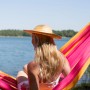 Frau entspannt in pink-orangener Amazonas Hängematte Santana am See.
