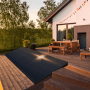 SUNNIVA Solarmodul 460W Full Black Bifazial Glas/Glas auf Holzterrasse vor Haus.