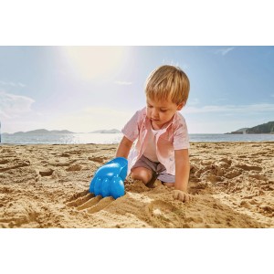 Kind spielt am Strand mit blauer Hape Power-Klaue aus Kunststoff.