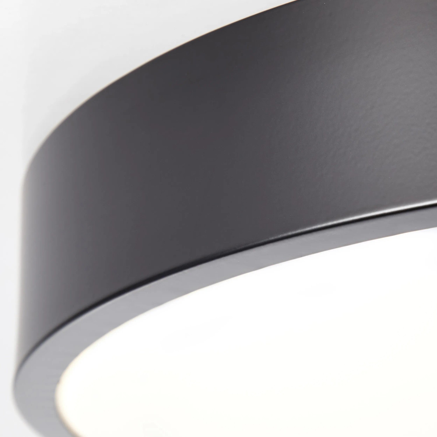 Detailaufnahme: Runde, schwarze LED-Deckenleuchte Slimline mit warmweißem Licht.