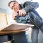 Mann sägt Holz mit LUX Akku-Stichsäge A-ST-20. Stichsäge mit Akku aus dem 1 PowerSystem.