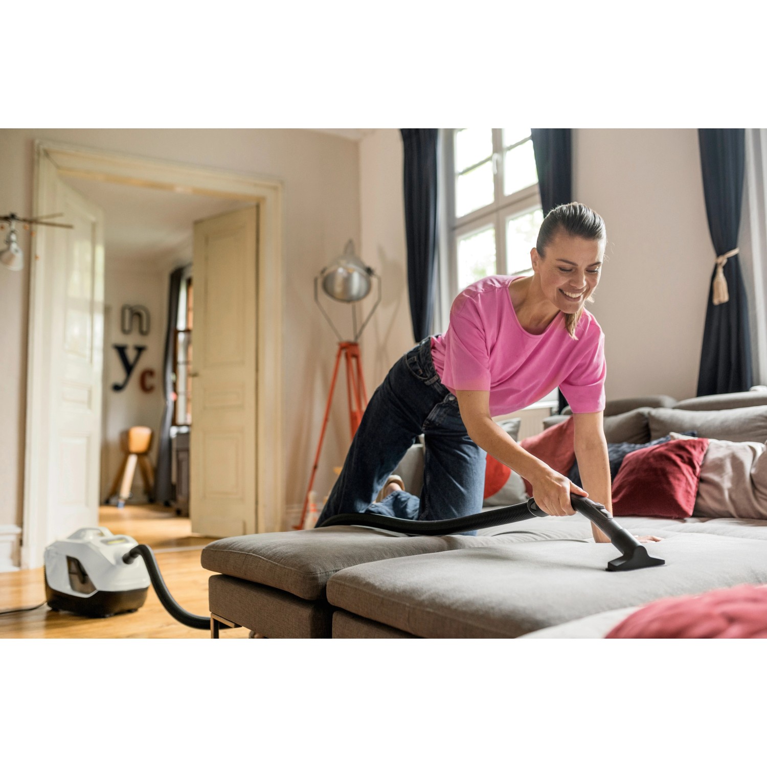 Frau saugt Couch mit Kärcher Staubsauger DS 6 mit Wasserfilter.