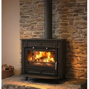 Plamen Gusskaminofen Glas Franklin, 11 kW, vor Steinwand mit brennendem Holz