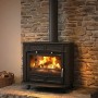 Plamen Gusskaminofen Glas Franklin, 11 kW, vor Steinwand mit brennendem Holz