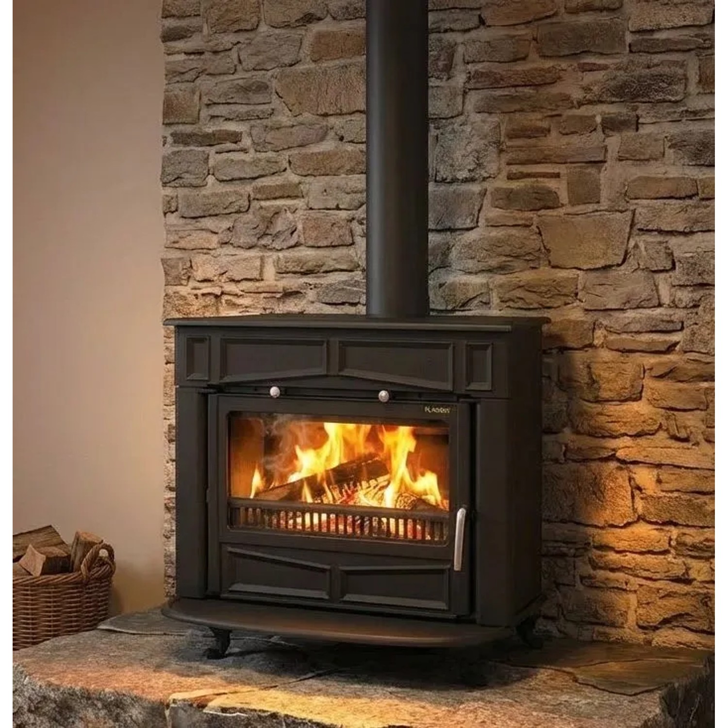 Plamen Gusskaminofen Glas Franklin, 11 kW, vor Steinwand mit brennendem Holz