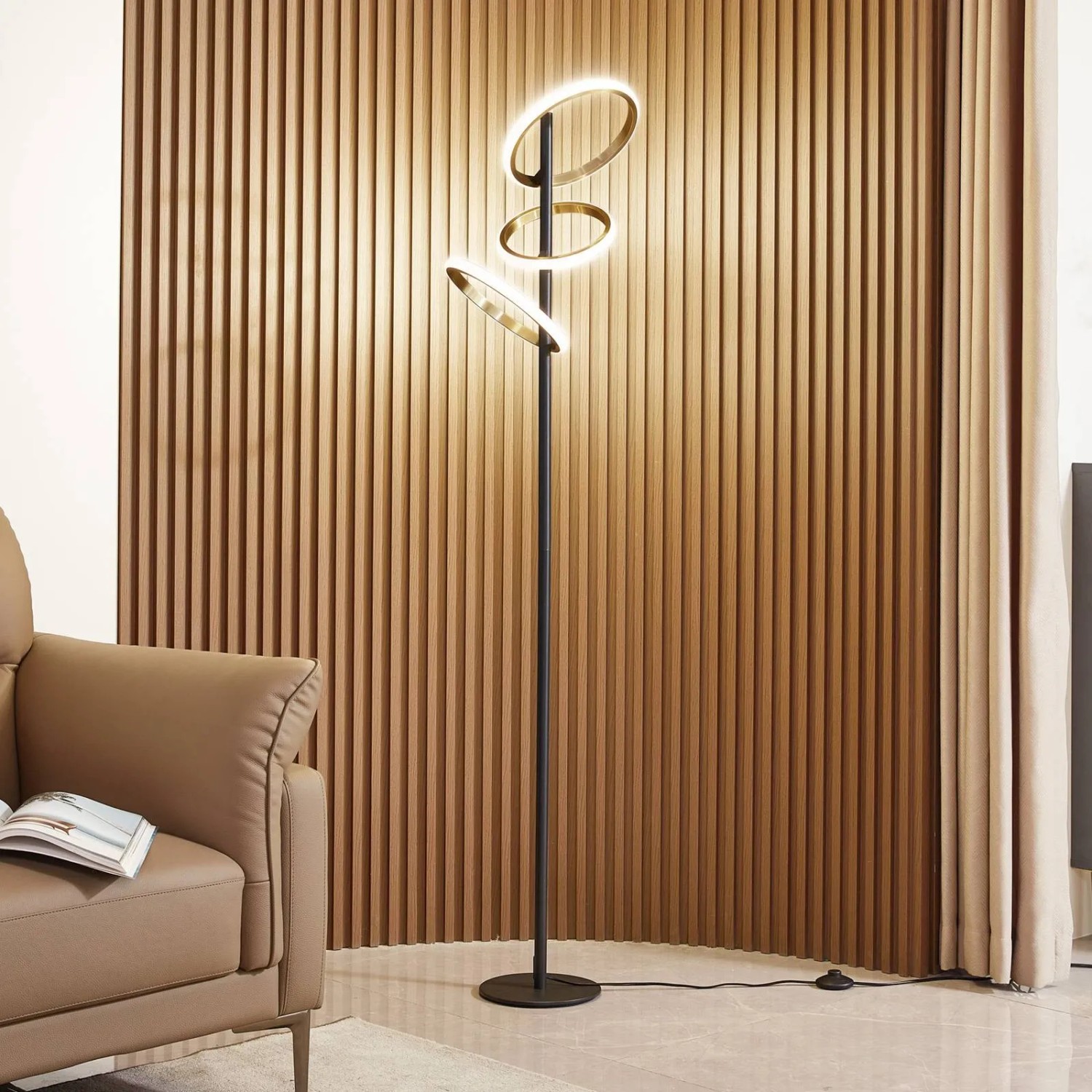 Moderne, dimmbare LED Stehlampe Madu in Schwarz mit drei ringförmigen Leuchtelementen.