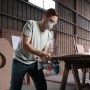 Mann sägt Holz mit Bosch Akku-Stichsäge aus dem 18V Akku-Geräte Kit.