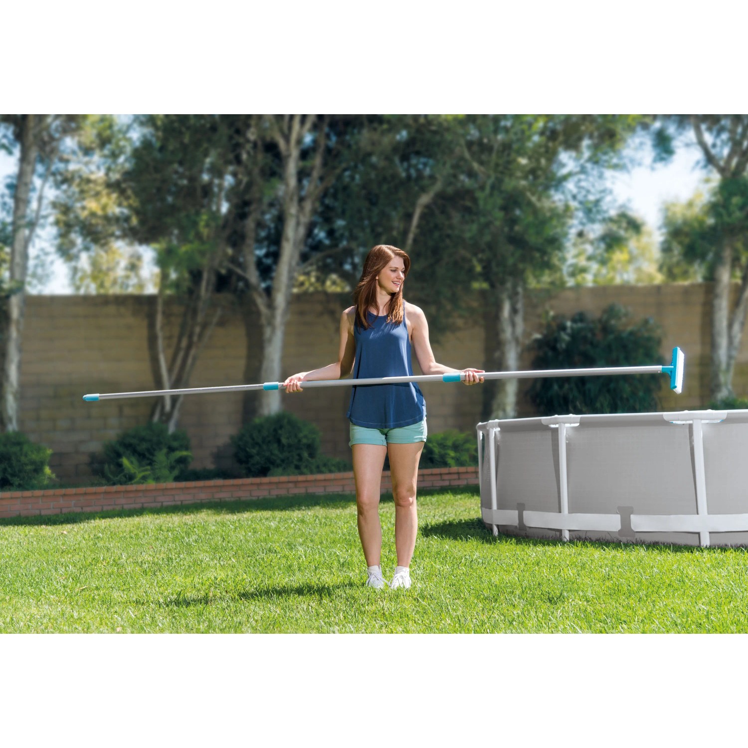 Frau hält Intex Reinigungs-Set Deluxe für Pools, bestehend aus Kescher, Bürste und Saugschlauch.