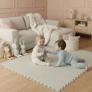 Zwei Babys spielen lachend auf einer beigen LittleTom Puzzlematte. Die 18-teilige Schaumstoffmatte bietet Kindersicherheit.