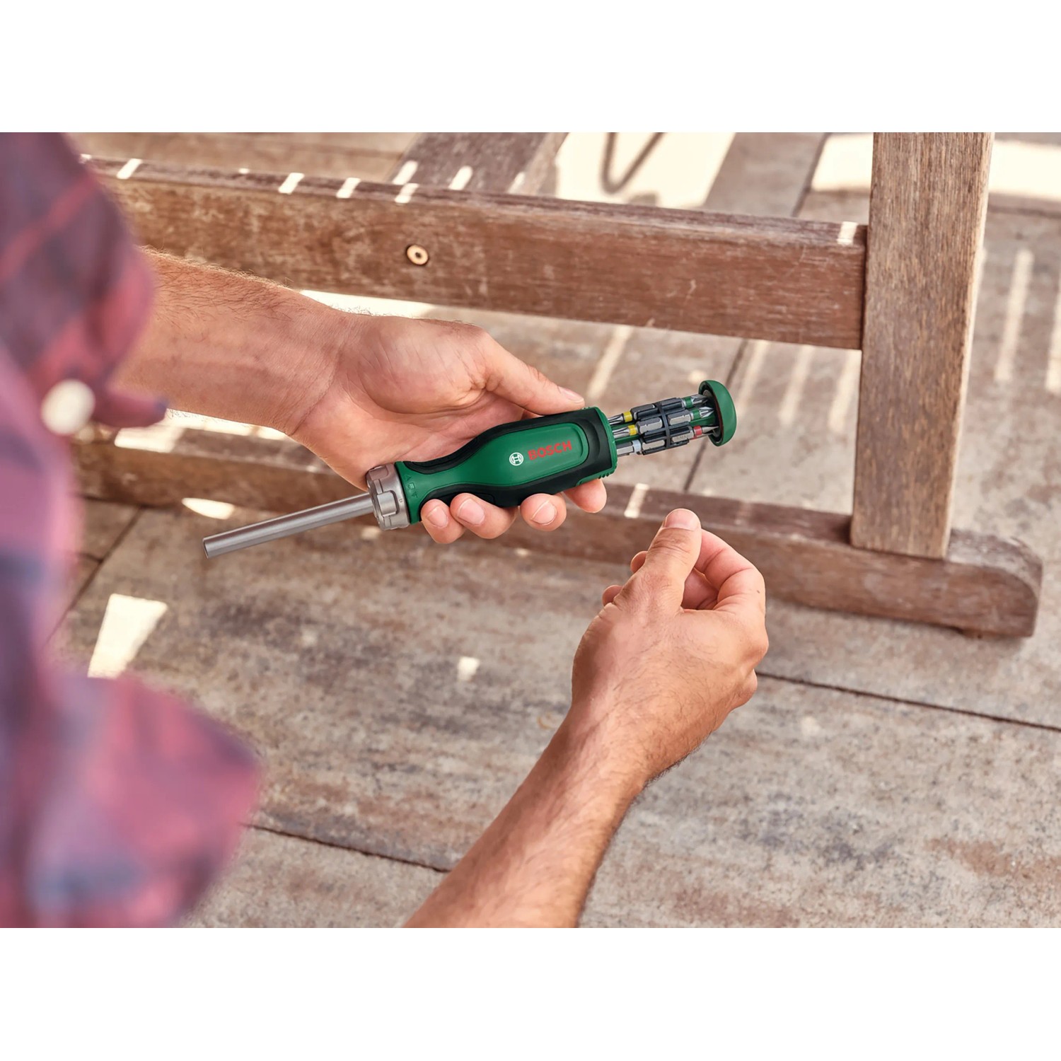 Bosch Bit-Ratschenschraubendreher mit 12 Bits in Aktion, Schraubenzieher mit grünem Griff.
