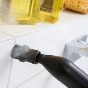 Kärcher Dampfreiniger mit Rundbürste im Einsatz zur Reinigung von Fliesenfugen im Bad.