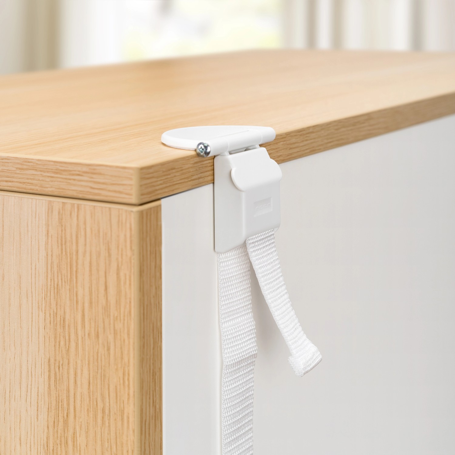 Reer Möbel-Kipp-Sicherung am Möbelstück befestigt, weiße Ausführung.