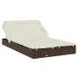 Braune 2-Personen-Sonnenliege mit Dach aus Poly Rattan und cremefarbenen Kissen.