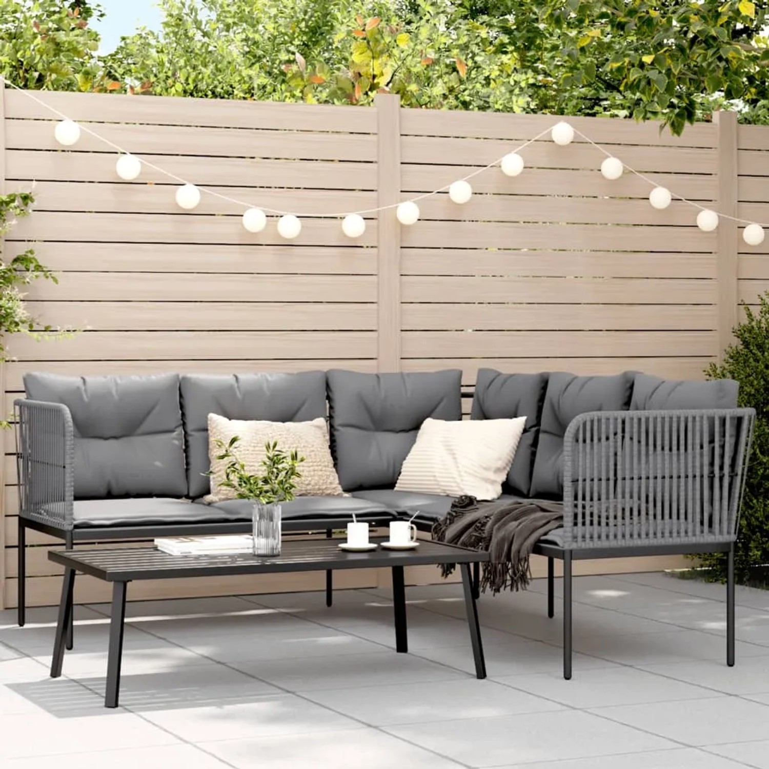 Schwarze vidaXL Garten-Sofagarnitur mit Kissen und Tisch auf einer Terrasse.