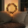Dekorativer Kranz mit Konstsmide Micro LED-Lichterkette Slim Frosted, bernsteinfarben, im gemütlichen Ambiente.