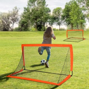 Kind schießt Ball in orange-schwarzes HOMCOM Fußballtor aus Metall auf Rasen. Tragbares Tor für Outdoor-Spiel.