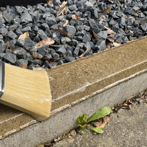 Auftragen von transparentem HSS Flüssigkunststoff auf eine Betonoberfläche mit einem Pinsel.