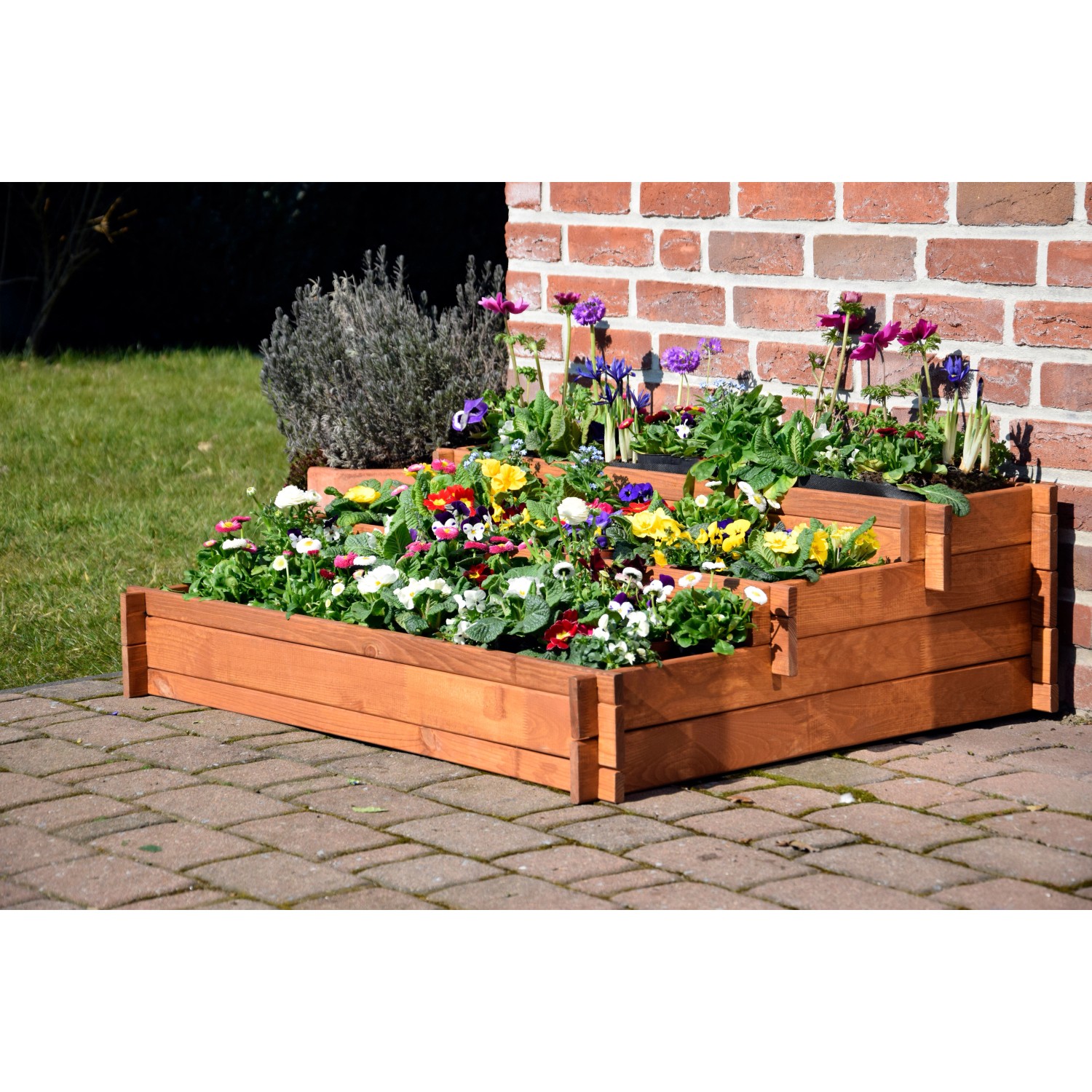 Dobar 3-Etagen-Hochbeet Peru aus FSC®-Holz, bepflanzt mit bunten Blumen, vor einer roten Backsteinmauer.