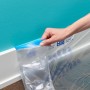 ScotchBlue Malerabdeckfolie mit Klebeband wird an einer Wand angebracht.
