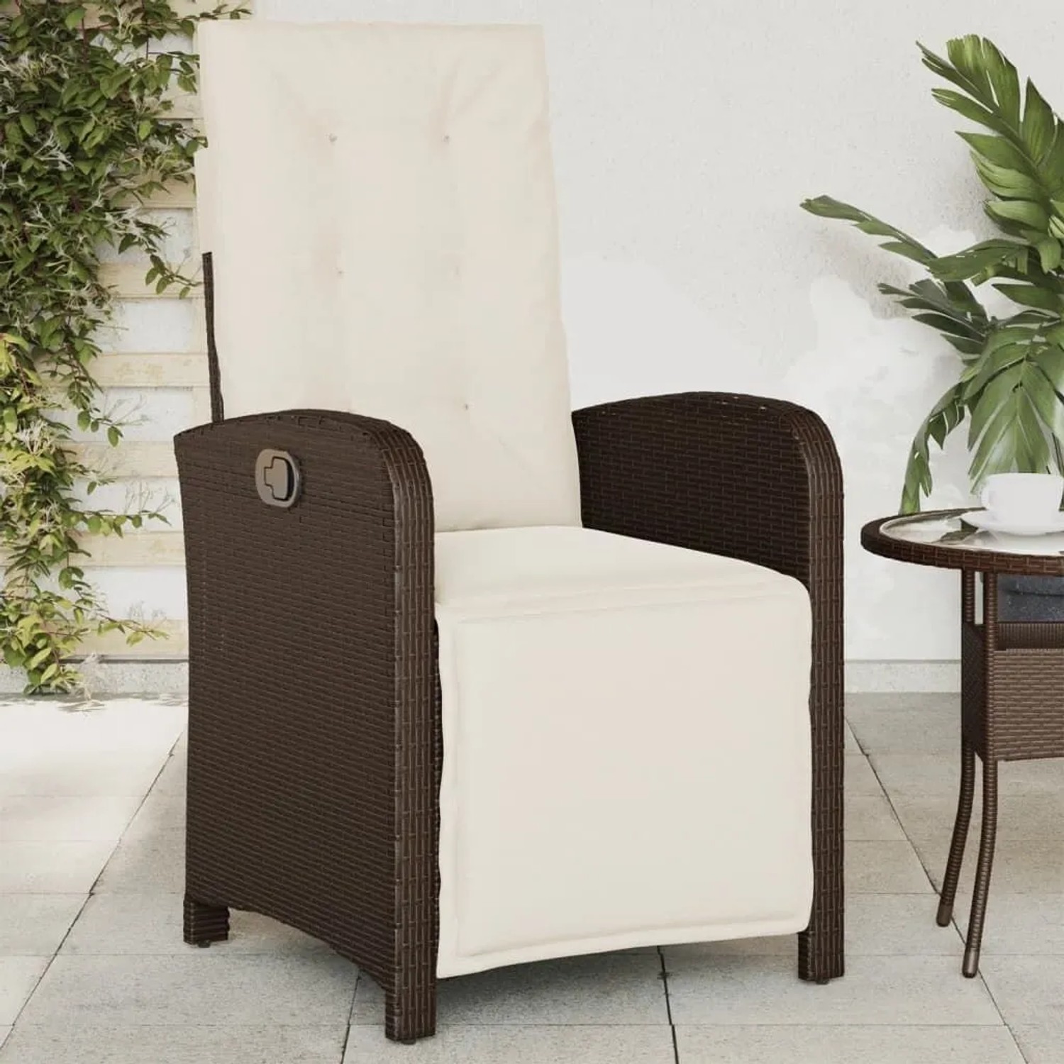 Brauner Poly Rattan Gartensessel mit cremeweißen Kissen, verstellbarer Rückenlehne und Fußteil auf der Terrasse.