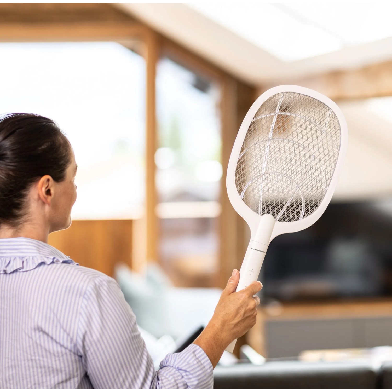 Frau hält Windhager Fliegenklatsche 2-in-1 elektrisch im Innenraum.