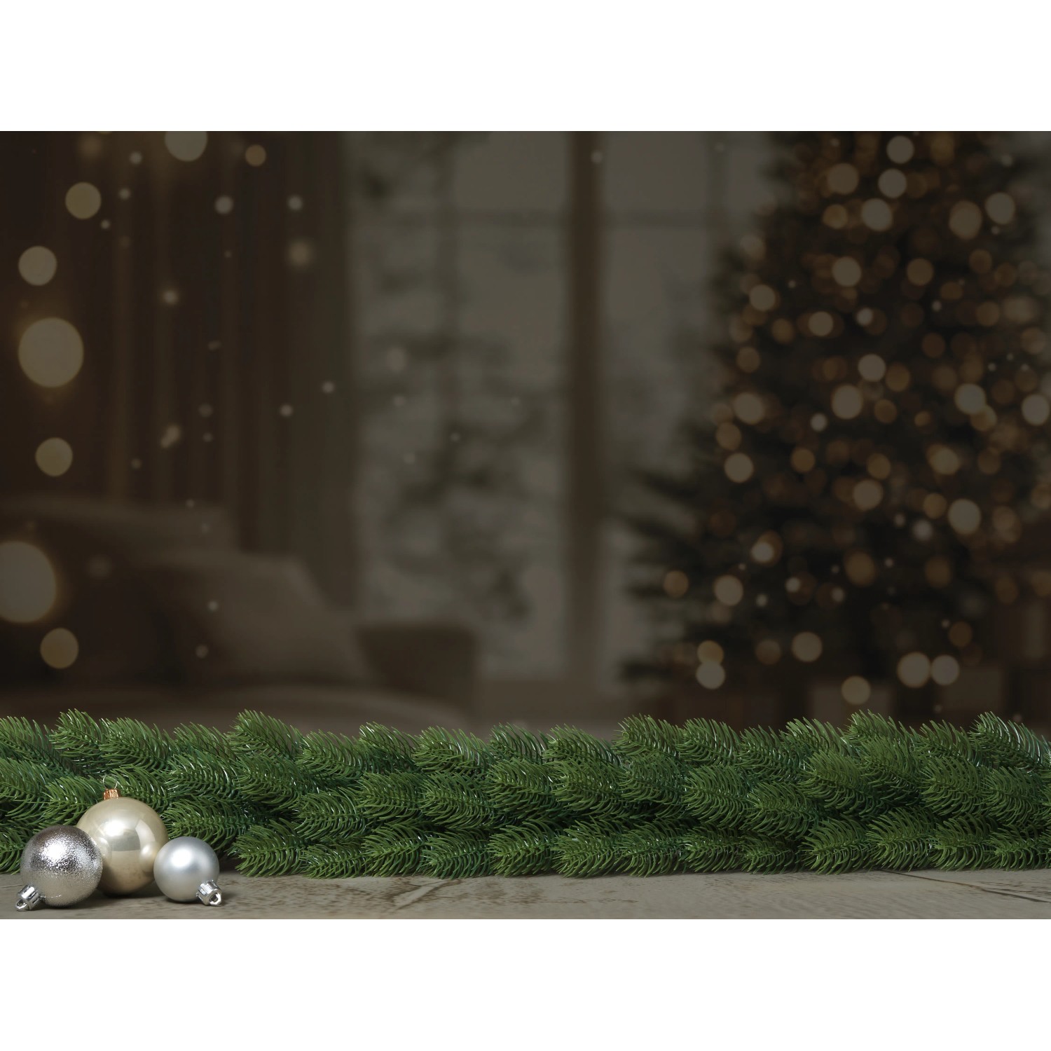 Künstliche Tannengirlande Nagano, 180 cm, mit silbernen Kugeln auf Tisch, Weihnachtsbaum im Hintergrund.
