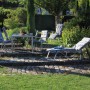 Gartenmöbel mit Beo Hochlehner-Saumauflagen Belgrad Karo in Grau-Anthrazit auf Stühlen und Liegen.