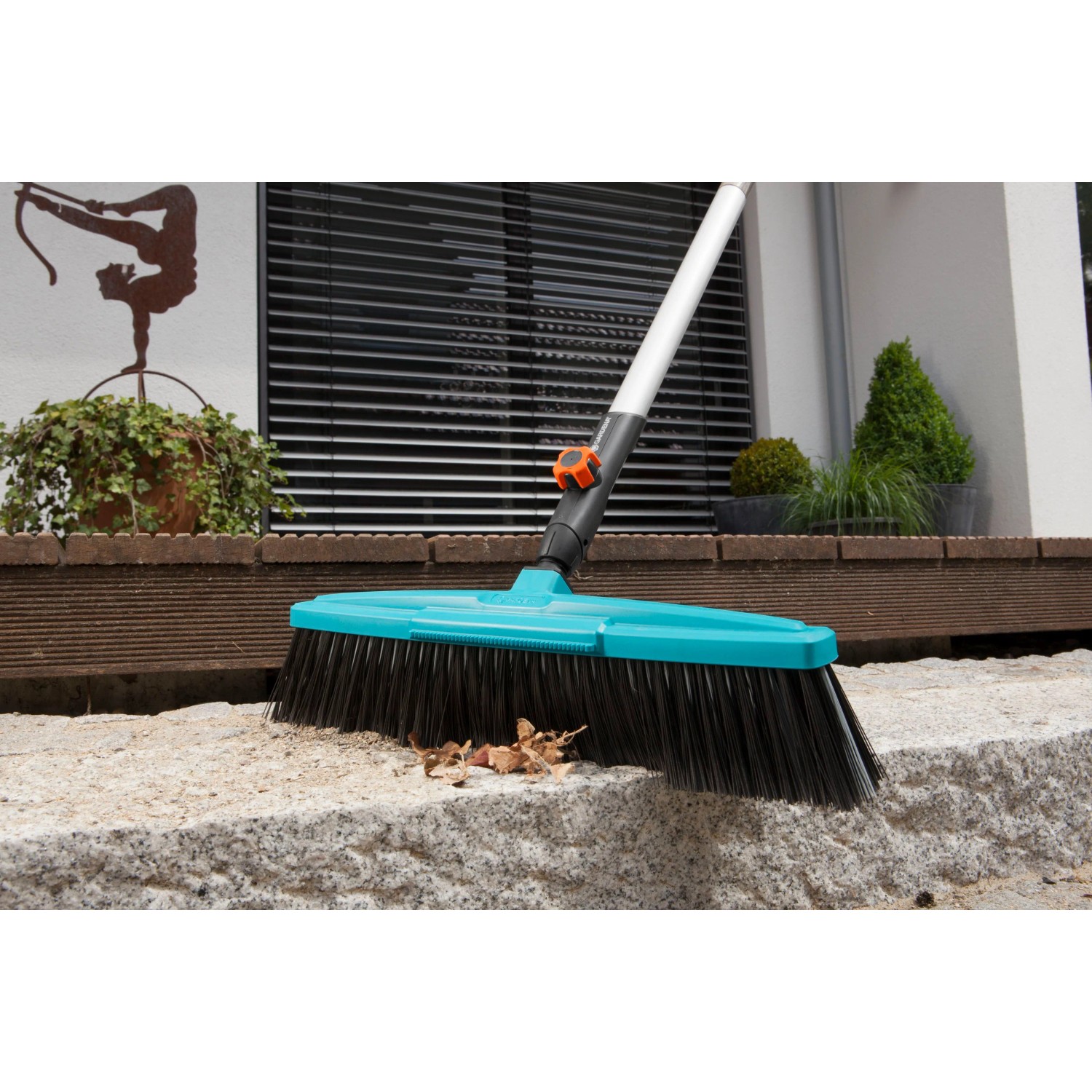 Gardena Combisystem Straßenbesen mit blauer Bürste und Kratzkante zum Entfernen von Schmutz.