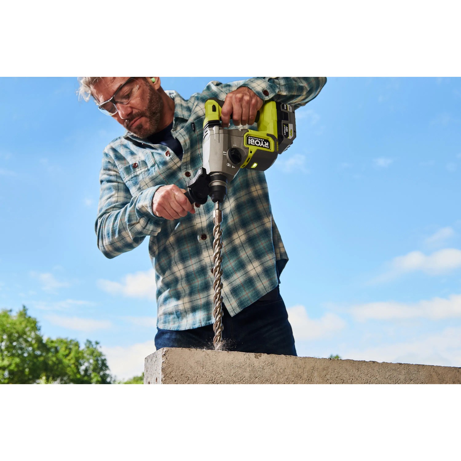 Mann bohrt mit Ryobi Akku-SDS-Bohrhammer RSDS18BL-0 in Beton.