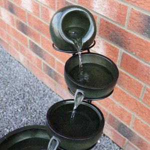 Monstershop Solar Kaskadenbrunnen Grun mit vier Schalen und Wasserlauf im Garten.