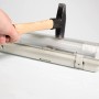 Hammer schlägt auf graue LED-Feuchtraumleuchte 120cm. Schlagfestigkeitstest.